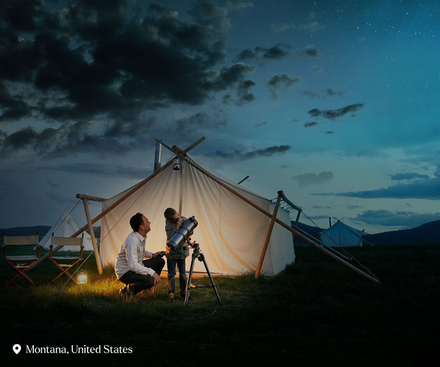 Father and son looking through telescope - stock photo