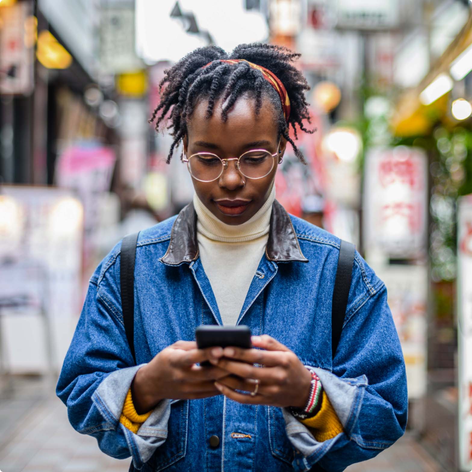 A woman standing in the street looking at her phone