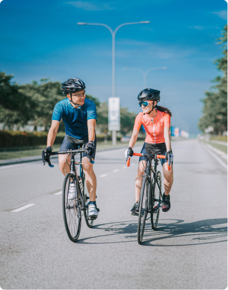 Two friends cycle along a road